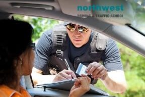 policeman gives driver a traffic ticket