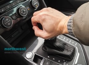 driver holds gear lever of car
